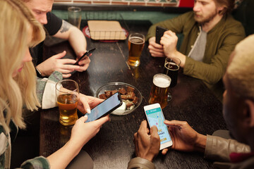 Sticker - Group of young intercultural friends having beer and scrolling in mobile gadgets