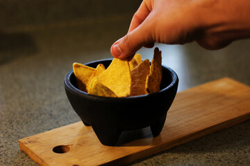 hand grabbing a mexican nacho chip 