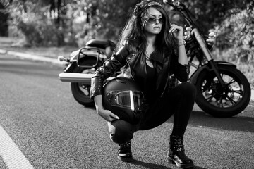 Wall Mural - Black and with woman in leather jacket and pants, by the motorcycle on the road