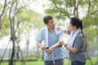 © Suriyo - Asian Middle aged couples exercising together with a scooter in city park, woman wiping the sweat off her husband after exercising.