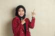 Young asian business woman wearing hijab smiling confident pointing with fingers to different directions. Copy space for advertisement
