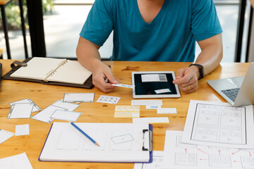 Graphic designers work together with UX UI designer planning application template layout framework for mobile phone computer mobile