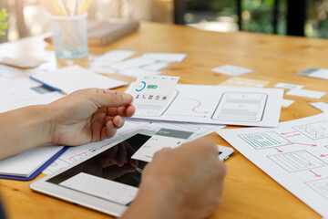 Graphic designers work together with UX UI designer planning application template layout framework for mobile phone computer mobile