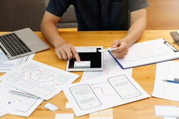 Graphic designers work together with UX UI designer planning application template layout framework for mobile phone computer mobile