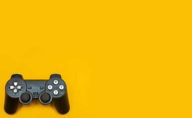 Black joystick gaming controller on trendy yellow background with space for text: video game console concept for Interactive Entertainment gamer 