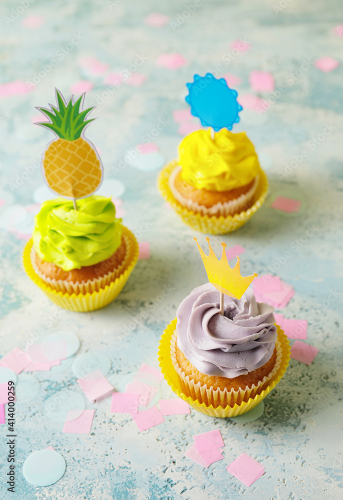 Tasty cupcakes with stylish toppers on light background