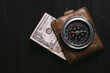vintage banknotes on wooden board with old vintage compass