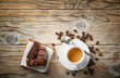 Espresso cup, biscuits and coffee beans on wooden background, top view, space for text.