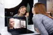 © Viorel - Online makeup tutorial. The make-up artist on the laptop screen, the student looking in the professional mirror, does the makeup. Specialized distance learning