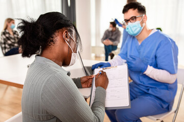 Wall Mural - Patient fills out the forms before receiving vaccine in clinic.