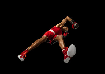 Wall Mural - Young african-american professional boxer in action, motion isolated on black background, look from the bottom. Concept of sport, movement, energy and dynamic, healthy lifestyle. Training, practicing.