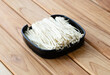 fresh raw mushroom sliced on square plate isolated on wooden background, shabu, hot pot ingredients