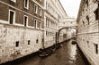 Gondolas floating on canal towards Bridge of Sighs (Ponte dei Sospiri). Venice, Italy. Perspective. Sepia historic photo.