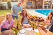 © Impact Photography - Friends having poolside backyard barbecue party