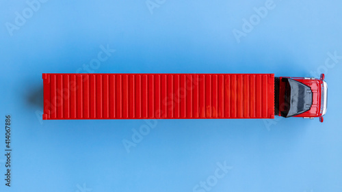 Obraz Dibond Semi trailer truck lorry container cargo vehicle on blue background, View from above, Aerial top view of semi truck with container cargo, Business logistic and transportation compay.