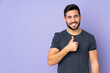 © luismolinero - Caucasian handsome man giving a thumbs up gesture over isolated purple background