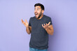 © luismolinero - Caucasian handsome man with surprise facial expression over isolated purple background