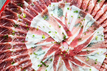 Wall Mural - fresh raw pork, meat ,beef, belly, sliced on square dish disk plate  on fabric and wood, wooden background, shabu, hot pot ingredients.