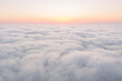 Aerial view from above the clouds during sunrise as seen from a drone.