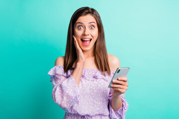 Wall Mural - portrait of impressed brunette girl hold telephone open mouth hand face wear purple shirt isolated o