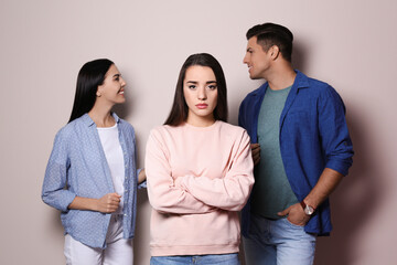 Wall Mural - Unhappy woman feeling jealous while couple spending time together on grey background