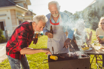 Wall Mural - Elderly neighbors grilling meat at the backyard