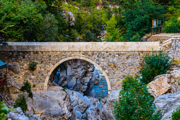 Wall Mural - Old stone bridge across river in canyon not far from the city Kemer. Antalya province, Turkey