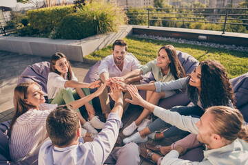 Photo of entrepreneurs sitting beanbags support cooperation training outdoors outside workshop workstation urban city terrace