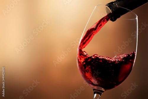 Red wine pouring from the bottle in glass © BillionPhotos.com