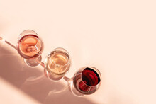 Glasses Of Red, Rose And White Wine With Sunshine Shadow Effect. Concept Of Wine Tasting. Flat Lay, Top View.