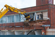Demolition Of An Old Building With A Long Reach Machine Hydraulic Jaw. Regeneration Of A Space For New, Modern Building.