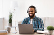 © Prostock-studio - African Man Working On Laptop Wearing Headphones At Workplace Indoor