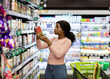 © Prostock-studio - Pretty African American woman choosing groceries at supermarket, shopping for food, buying products for her family