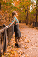 Wall Mural - A girl stands on the bridge in autumn female lifestyle, holiday relaxation relax caucasian, looking. tourism teenage, river