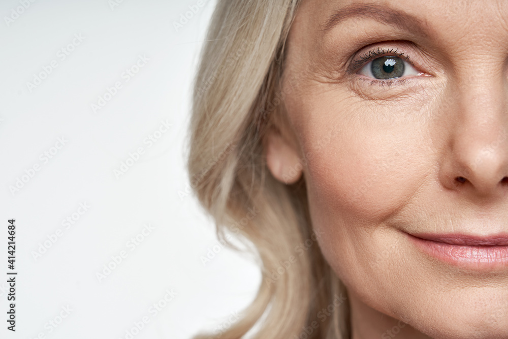 50s middle aged old woman looking at camera isolated on white background advertising dry skin care treatment anti age skincare beauty, plastic surgery, cosmetology procedures. Close up half face view - obrazy, fototapety, plakaty 