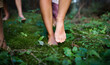 Bare feet of family with small children standing barefoot outdoors in nature, grounding concept.