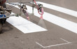 © Chinart - Painting machine paints stripes on asphalt for pedestrians.