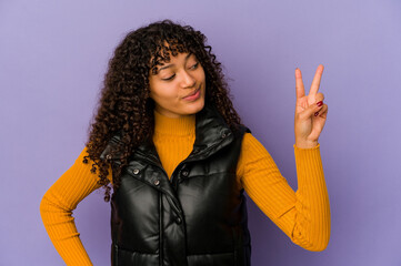 Wall Mural - Young african american afro woman isolated joyful and carefree showing a peace symbol with fingers.