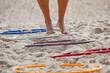 © BrunoMartinsImagens - feet doing exercises on a functional exercise ladder on the beach sand.