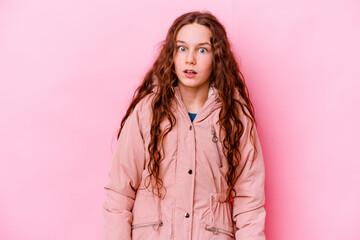 Wall Mural - Little caucasian girl isolated on pink background being shocked because of something she has seen.