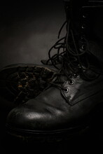 A Pair Of Old, Worn, Black Leather Army Boots, With Traces Of Dirt And Mud On Them.