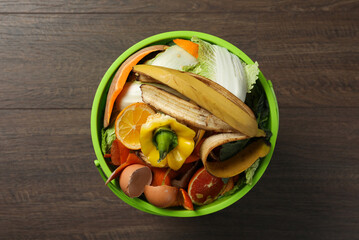 Wall Mural - Trash bin with organic waste for composting on wooden background, top view