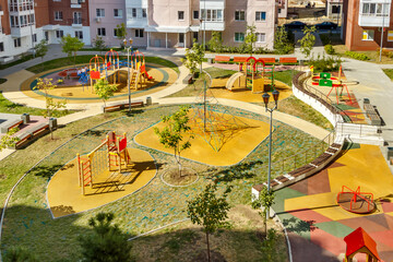 top view of empty new modern children playground in courtyard of high-rise residential buildings in 