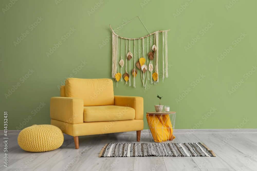 Armchair and table near color wall in room