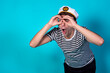 © Denis - Funny experienced sailor ready for marine travel. Cheerful young sailor. Expression of emotions. The guy is posing on a blue background.