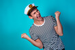 © Denis - Funny experienced sailor ready for marine travel. Cheerful young sailor. Expression of emotions. The guy is posing on a blue background.