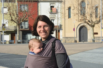 portrait of a woman carrying her child in an urban setting