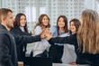 © Semachkovsky  - Amazing happy workers holding hands forming a teamwork sign and smiling contented in the office. Working day concept
