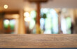 © Charlie's - Empty wooden table in front of abstract blurred background of coffee shop . can be used for display or montage your products.Mock up for display of product