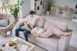 © deagreez - Full size photo of positive young parents sit lie couch talk expect baby enjoy rest indoors in house living room